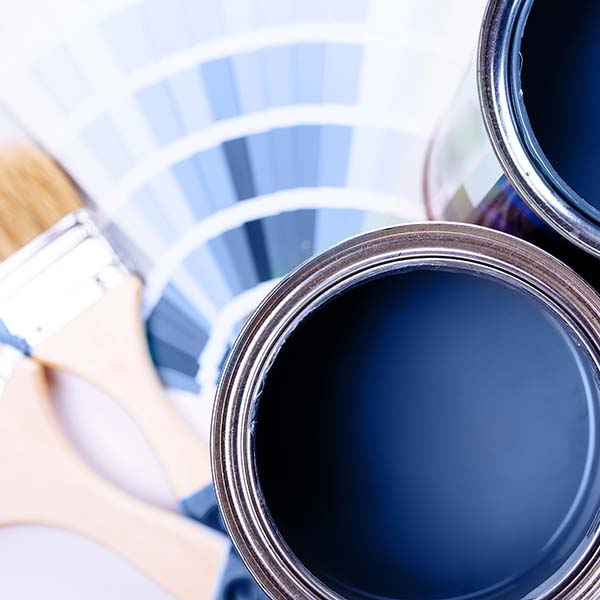 Paint brushes placed on top of can filled with blue paint. Classic blue color of year 2020.